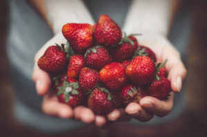 Eine Frau hält Erdbeeren in Händen